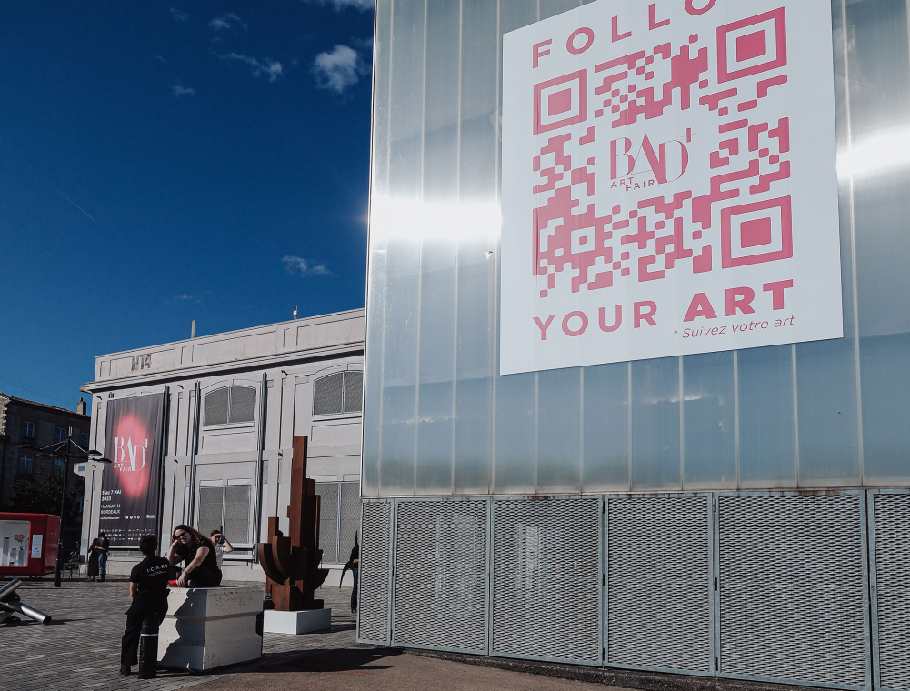 Façade du hangar 14 avec l'affichage descriptif de l'exposition BAD+ Art Fair et le QR Code menant au site de cette exposition.