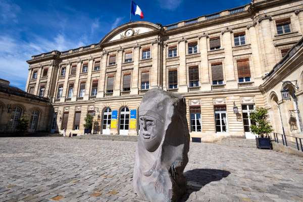 Sur le parvis devant l'hôtel de ville de Bordeaux, une grande sculpture représentant un visage est exposé, cette exposition s'appelle Monumentales.